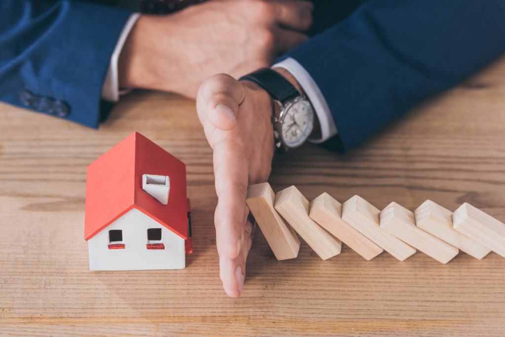 Falling wooden blocks stopped by a hand before a house